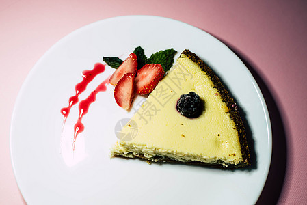 白盘上一块芝士蛋糕蓝色工具饼干棉布黄油盘子面包餐巾桌子美味图片