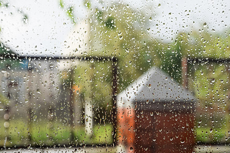 窗玻璃上的雨滴 雨中窗外模糊的背景气泡季节生活淋浴风景湿度树叶街道房子植物图片