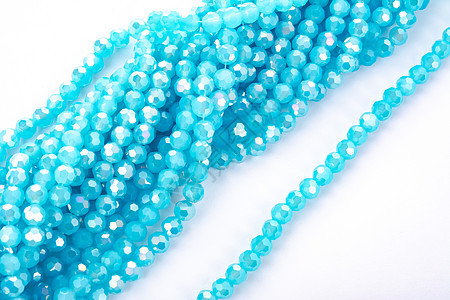 白色背景上美丽的浅蓝色玻璃闪光水晶 Isoalted 珠 用于 DIY 珠宝商爱好蓝色装饰宝石礼物火花项链手镯手工宏观图片