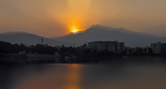 黎明时 山地和湖泊的风景 在晨日中 云层后升起 廷达尔效应对水的影响图片