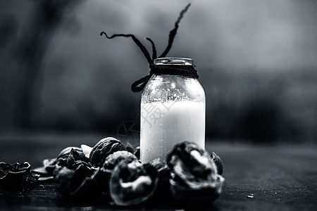 在一个粘土碗中的木质表面贴近胡桃或阿赫罗特 用一个小的透明瓶子做干果奶昔饮食产品乳糖液体饮料乡村小吃奶制品花生营养图片