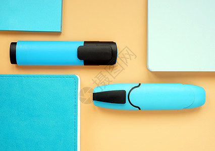 橙色表面的蓝色笔记板和标志 办公室供应的最顶端视线平坦背景图片