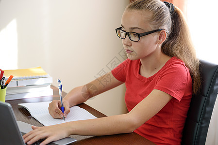 在笔记本电脑上做家庭作业校园桌面学校教育职场写作桌子记事本学生图书图片