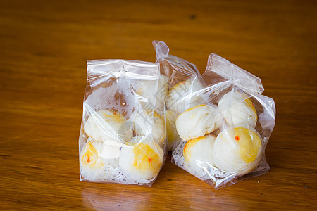 传统的中国蛋糕 装在木制背景的塑料袋里糕点店铺木头面包蜜饯甜点节日美食月亮食物图片