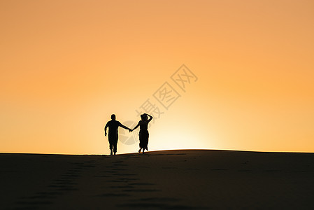 一对幸福的年轻情侣 以橙色苏为背景成人女士天空沙丘女孩自由喜悦家庭海滩沙漠图片