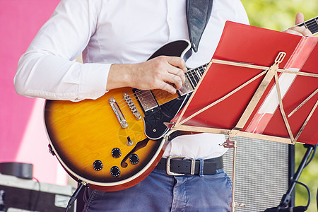 在城市公园爵士音乐节上演奏吉他手演员蓝调旋律晴天成人玩家男人公园音乐家团体图片