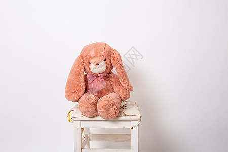 粉红色的兔子毛绒娃娃坐在白色背景的凳子上 复活节兔子 复活节野兔卡通片钩针乐趣孩子们孩子毛皮婴儿针织玩具童年图片