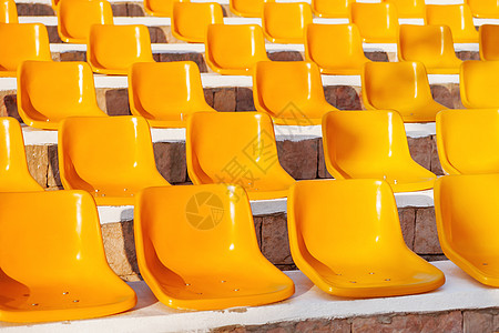 用黄色塑胶座椅的石头脚步 没有人的空凳子背景图片