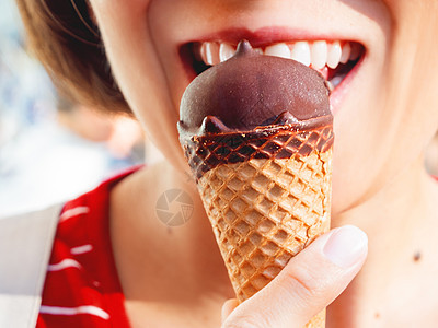 穿红衬衫的女人正在吃冰淇淋 快拍冷甜点的照片甜点阳光牙齿锥体微笑棕榈共鸣巧克力胡扯嘴唇图片