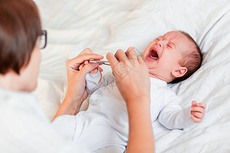 母亲用指甲剪刀切出新生儿的指甲 为小婴儿修指甲图片