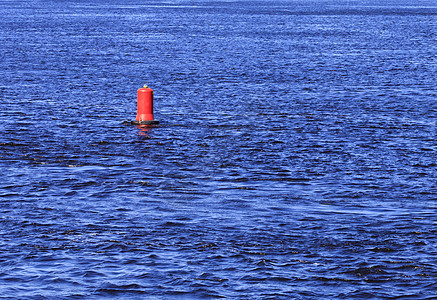 一条宽阔河流的蓝色波浪上的红浮标山图片