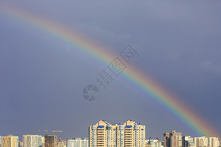 暴风雨过后 天上的彩虹在城市上方图片