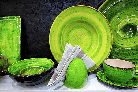 一张法兰绒餐巾和一套涂有亮绿色釉的陶器背景图片