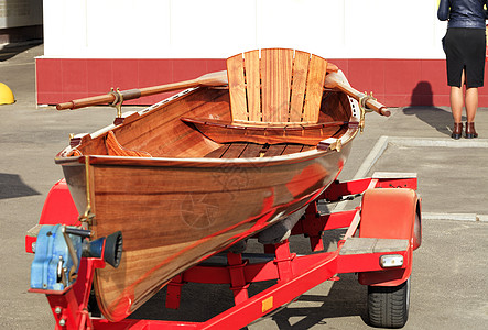一个橙色的木独木舟在停车场休息图片