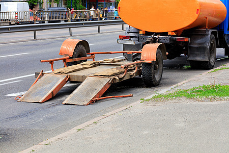 一辆旧的低平台拖车搭上一辆老卡车 停在公路上图片