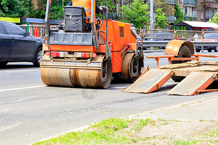 从低平台拖车上卸下重振动路过路的滚轮 并站在公路上图片