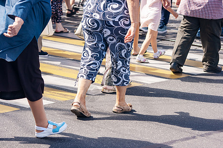 在人行道上行走的行人腿斑马团体交通人群城市行动沥青男人女性裙子图片