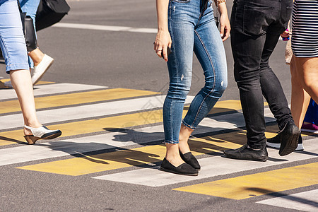 在人行道上行走的年轻行人腿斑马女性民众蓝色裙子运动牛仔裤人群沥青安全图片