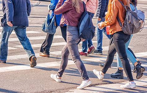跨过城市街道的青年女子双脚交通夹克场景蓝色人群城市团体安全女性关心图片