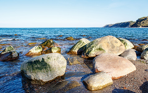 海砂 海浪在一块大石头上崩塌沿海海滩晴天地平线天气场景泡沫海岸海洋蓝色图片