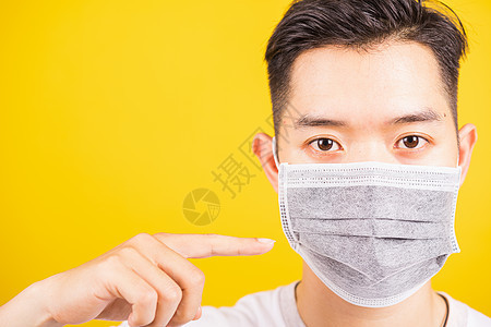 男子佩戴卫生外科手术防护面具 面罩防冠男人疾病女性流感手指医疗药品黄色安全工作室图片