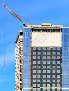 建造一座现代混凝土建筑 有玻璃面罩 反映蓝天和高塔起重机项目工地住房金属商业建筑学工作房子墙壁财产图片