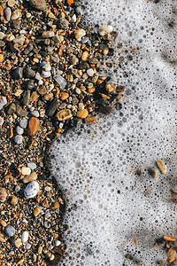 海浪泡沫泡沫背景的海岸上的海石图片