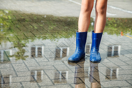 女孩穿着橡皮靴 在雨后站在水坑里靴子女性城市季节下雨街道乐趣天气孩子橡皮图片