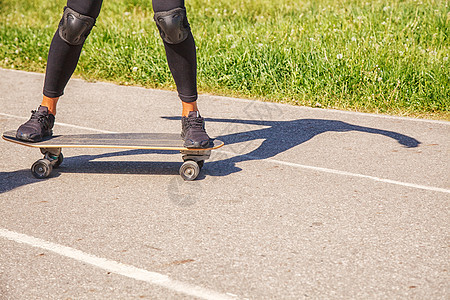 青年女子在公园滑板女性乐趣街道爱好运动潮人牛仔裤溜冰者滑冰女士图片