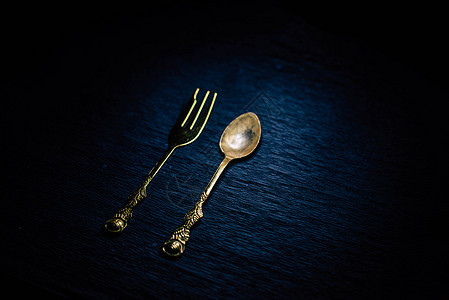 黑色背景上的经典叉子和勺子刀具饭馆桌子用具用餐金属食物工具厨房反射图片
