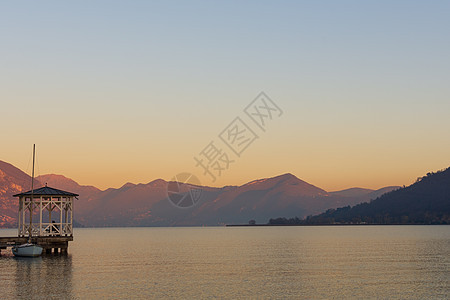 伊索湖宁静的水域上日落山脉沉着太阳天空全景海岸帆船旅行港口假期图片