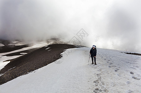 游客从山坡上爬到雪顶顶顶峰男人山脉远足旅游运动登山荒野路线蓝色远足者图片