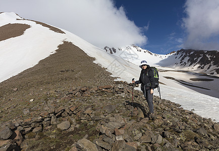 游客从山坡上爬到雪顶顶顶峰蓝色运动山脉女孩探索首脑成就旅行探险家太阳图片