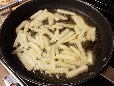 炸锅热油中的薯条薯条小吃午餐油炸火炉平底锅土豆烹饪气泡煎锅图片