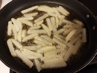 炸锅热油中的薯条薯条小吃火炉平底锅土豆油炸气泡煎锅烹饪午餐图片