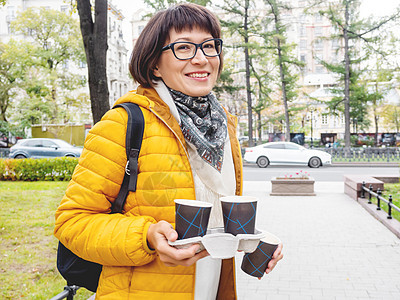带着咖啡 快乐地欢乐着微笑的女士们游客旅行女士公园旅游晴天杯子纸板情感眼镜图片