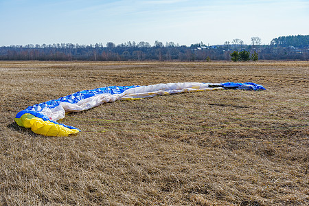 阳光明媚的一天 降落伞在田野干草上传播航班场地螺旋桨翅膀行动天空动力伞闲暇旅游运动图片