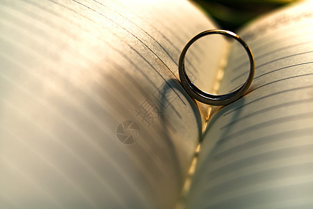 结婚戒指在t和t上投下的心脏阴影背景摘要图片