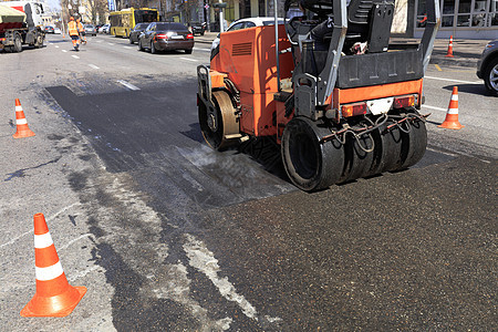 在城市街道上对路段进行振动性公路滚滚车维修背景图片