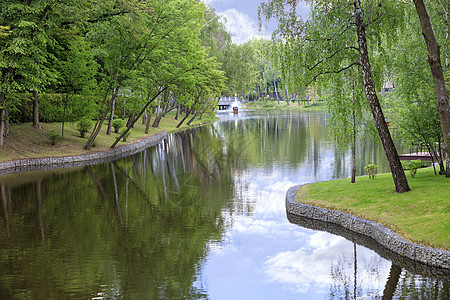 装饰性的池塘和漂浮鸭屋 和一个喷泉 在美丽的光滑的夏季公园图片
