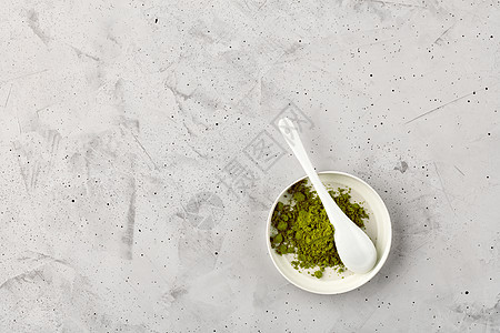 Matcha 绿色茶粉 用白陶瓷勺装在陶瓷杯中图片