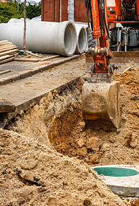 一桶重型建筑挖土机在修复公路上一名城市收藏家的同时 挖掘了一条战壕图片