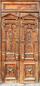 古老的风化木门 带有雕刻元素 翼上有乌克兰风格的对称图案图片