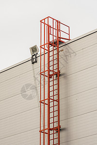红色火警逃至建筑物屋顶的红色防火梯技术天空建筑工业出口金属蓝色白色领导脚步图片