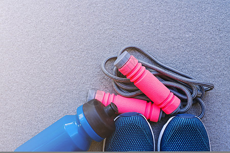 跳绳 跑鞋和在地上喝瓶酒绿色植物平铺绳索女士跑步者损失保健运动鞋体育场卫生图片