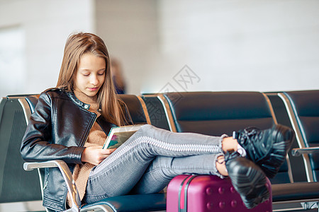 可爱的小女孩在靠近窗户的大国际机场机场闲暇女孩假期大厅行李运输手提箱孩子护照旅游图片