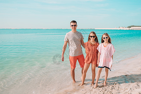 陪父母父亲和孩子们享受沙滩暑假父母跑步热带爸爸椰子异国家庭运动喜悦幸福背景