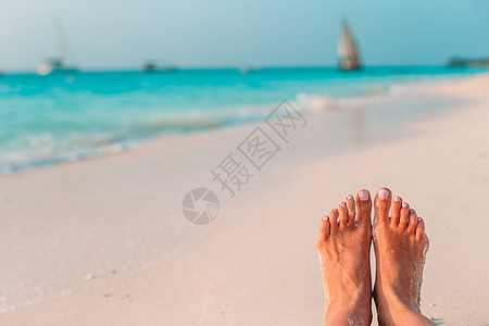 在浅水的白沙滩上 女人的脚阳光女性棕褐色晴天闲暇成人享受日光浴女士海岸线图片