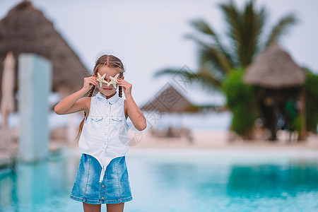 可爱的小女孩 海星在白空海滩上海岸线女孩动物群异国动物情调热带太阳镜生活酒店图片