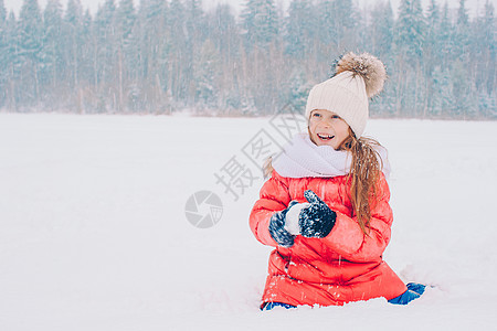 在阳光明媚的冬天天下雪时 可爱小女孩的肖像外套闲暇乐趣女儿季节毛皮夹克幸福童年微笑图片